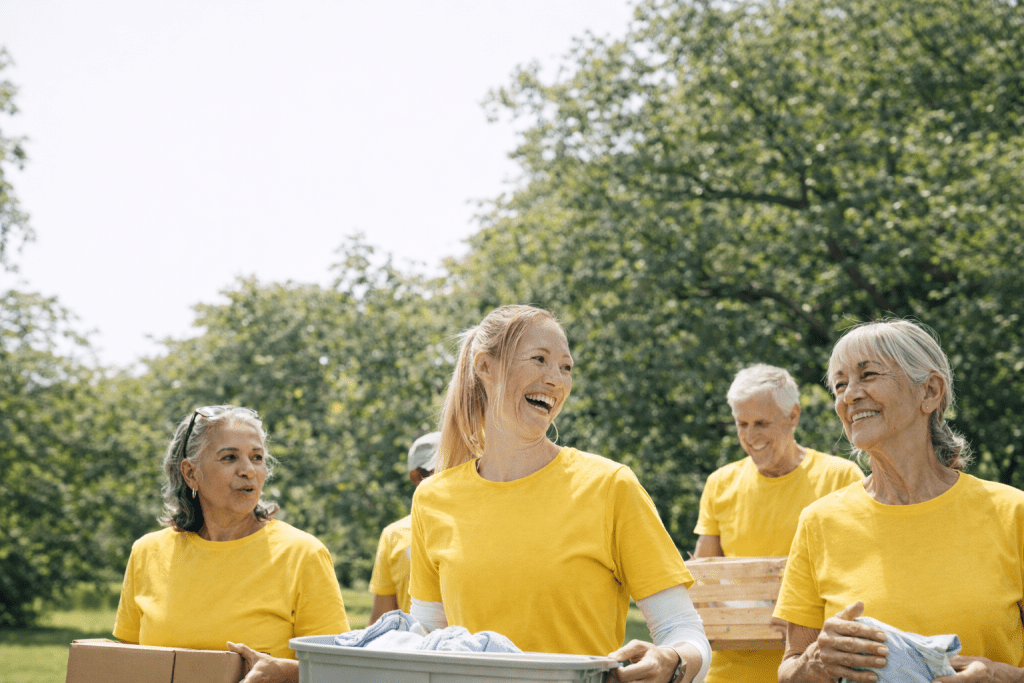 Lions volunteers working together outdoors, smiling and carrying supplies in a park setting.